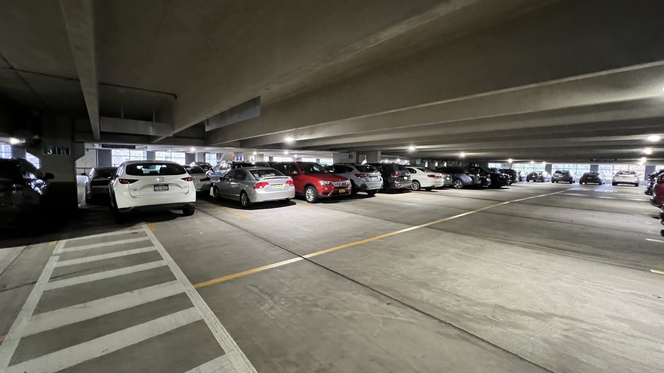 Cars parked in a double-tee parking structure, showing deck joints